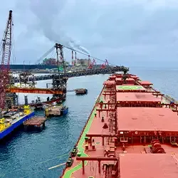 Bulk carrier vessels at iron ore loading terminal representing Universal Minerals Inc global shipping and logistics services