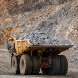 Haul truck loaded with magnetite iron ore at open pit mine representing Universal Minerals Inc iron ore supply