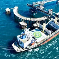Aerial view of a bulk cargo ship moored at an offshore loading terminal, representing UMI's global iron ore shipping and logistics solutions